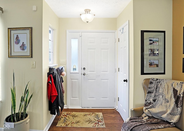 entryway with a textured ceiling and dark wood-type flooring