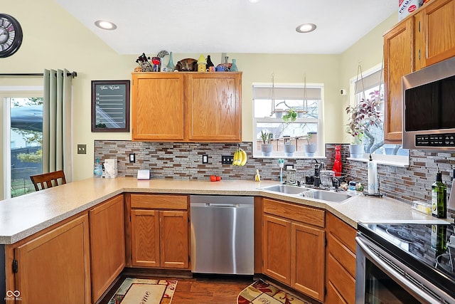 kitchen featuring a breakfast bar, sink, decorative backsplash, kitchen peninsula, and stainless steel appliances