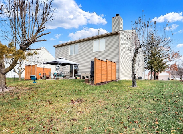 back of property with a gazebo and a yard