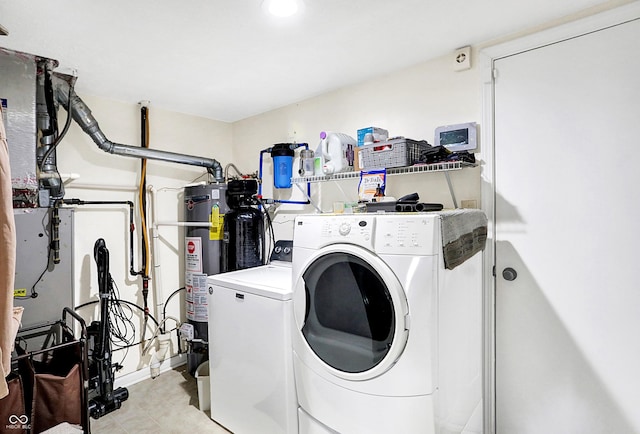 laundry room featuring secured water heater and independent washer and dryer