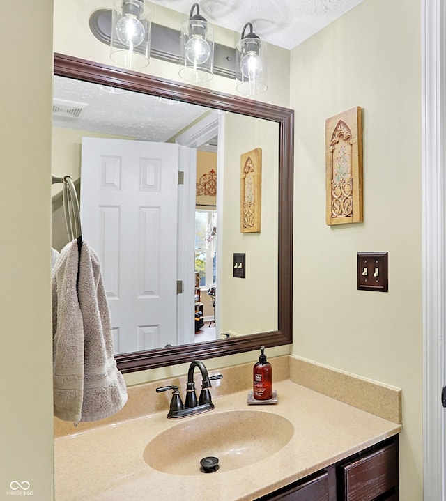 bathroom featuring a textured ceiling and vanity