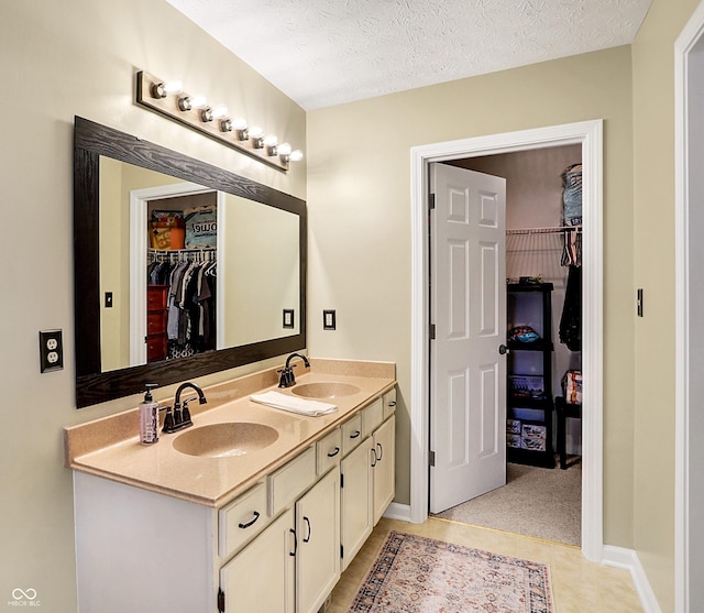 bathroom with tile patterned floors, vanity, and a textured ceiling