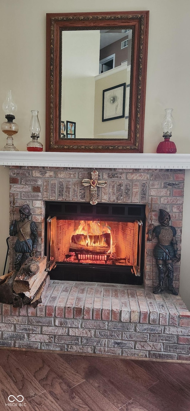 details with wood-type flooring and a brick fireplace