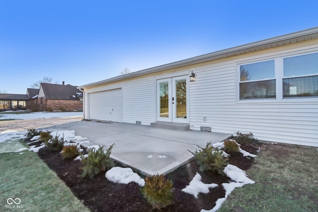 back of house with french doors, a garage, and a patio area