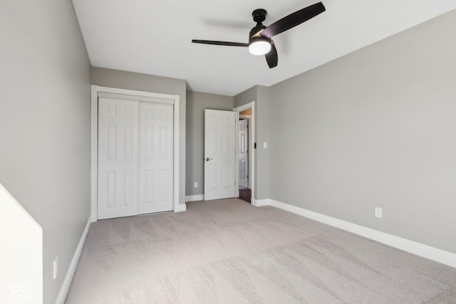 unfurnished bedroom featuring ceiling fan, light colored carpet, and a closet