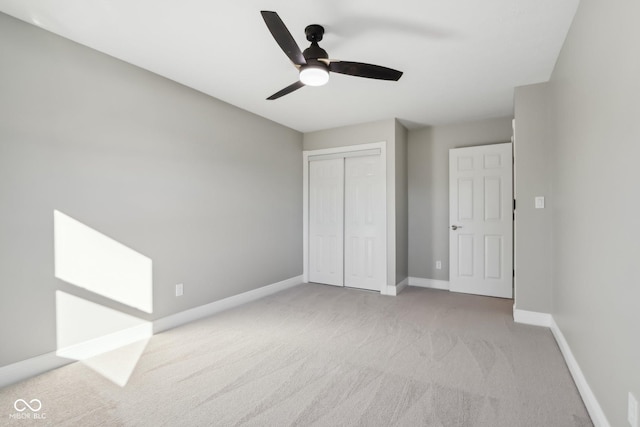 unfurnished bedroom featuring light colored carpet, a closet, and ceiling fan