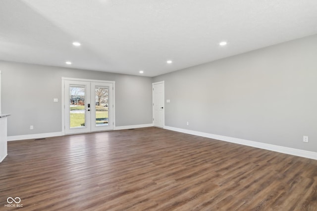 unfurnished living room with dark hardwood / wood-style floors and french doors