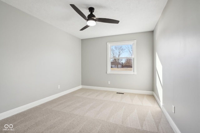 spare room featuring ceiling fan and light carpet