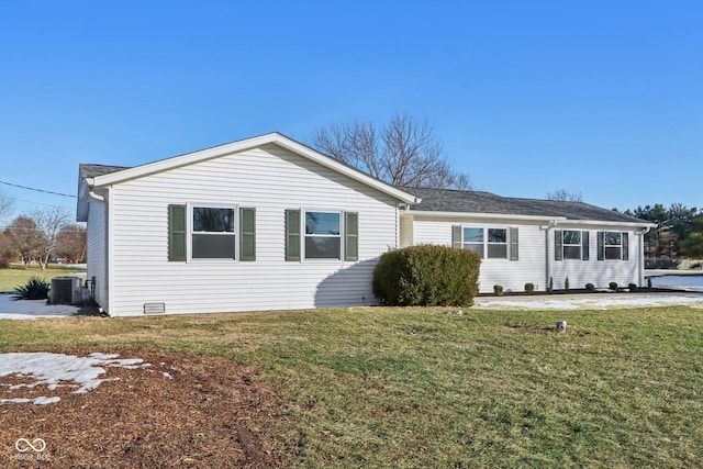 ranch-style home featuring central AC unit and a front lawn