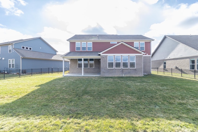 back of house featuring a lawn and a patio