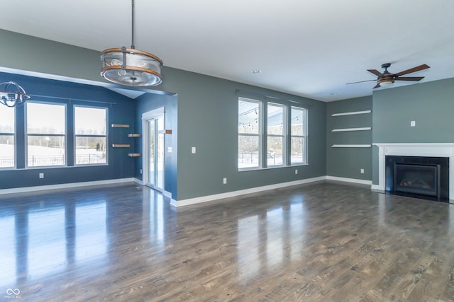 unfurnished living room with built in shelves, ceiling fan, and dark hardwood / wood-style flooring