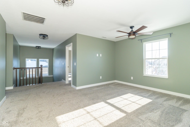 carpeted empty room featuring ceiling fan and a healthy amount of sunlight