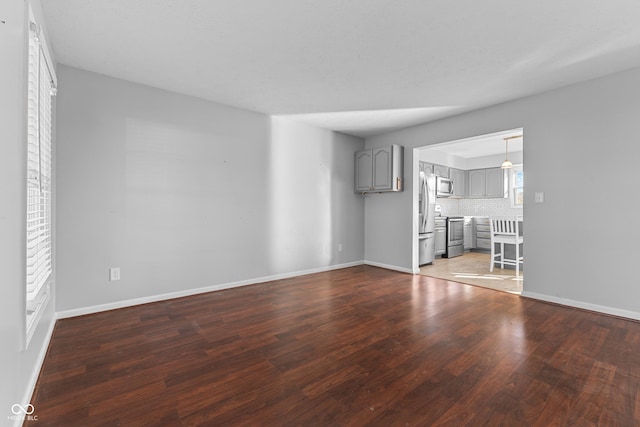 unfurnished living room featuring wood-type flooring and a wealth of natural light