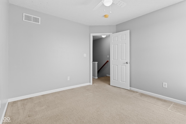 unfurnished room featuring ceiling fan and light carpet