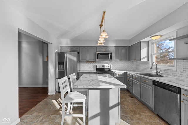 kitchen with a center island, stainless steel appliances, gray cabinets, and sink