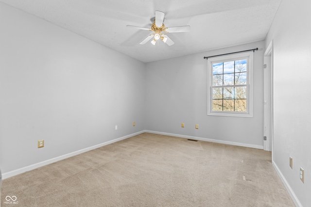 unfurnished room with light carpet, ceiling fan, and a textured ceiling