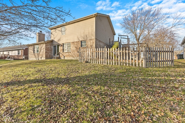 rear view of property with a lawn