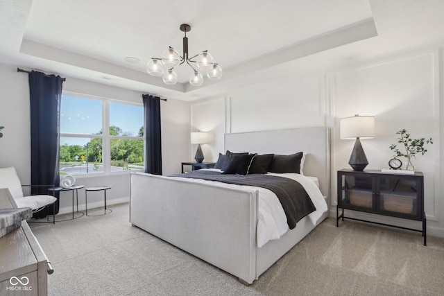 bedroom with a raised ceiling, light carpet, and a chandelier