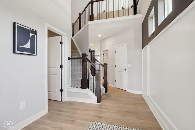 interior space featuring light wood-type flooring and a high ceiling