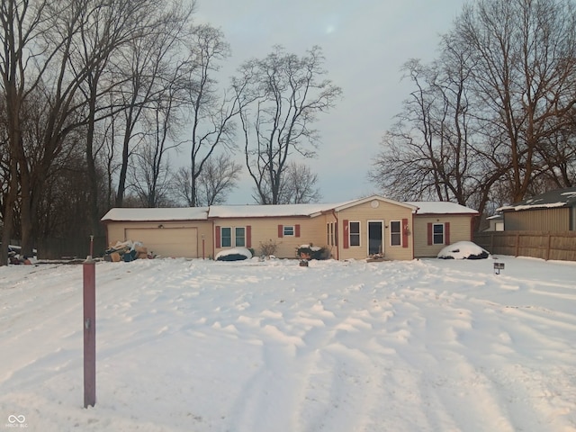 snow covered house featuring a garage