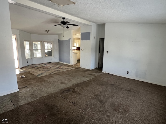 unfurnished living room featuring ceiling fan, lofted ceiling with beams, carpet, and a textured ceiling