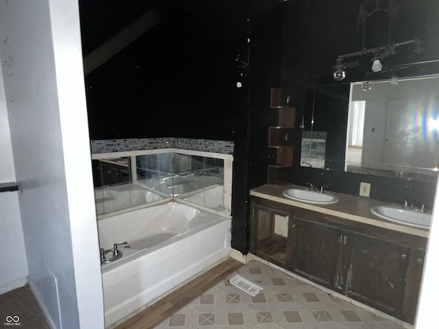 bathroom with a tub and vanity