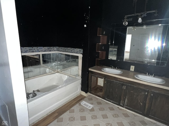 bathroom with a tub and vanity