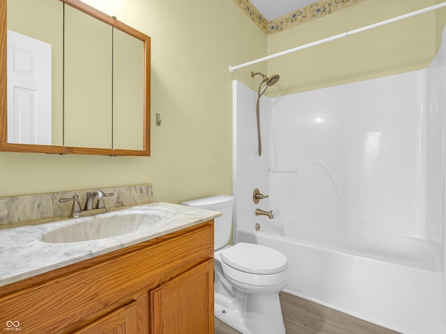 full bathroom with toilet, vanity,  shower combination, and hardwood / wood-style flooring