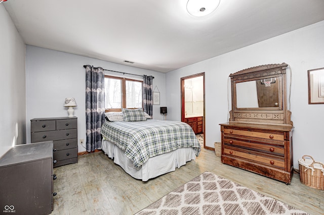 bedroom with connected bathroom and hardwood / wood-style floors