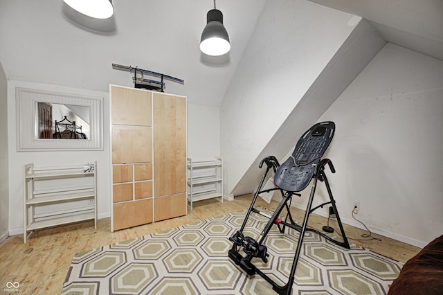 exercise area featuring vaulted ceiling and light hardwood / wood-style floors