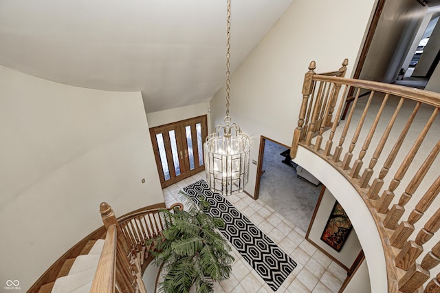 stairs featuring lofted ceiling and an inviting chandelier