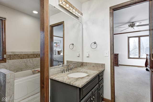 bathroom with a bathing tub, vanity, and ceiling fan