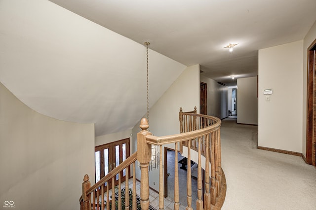 hallway featuring vaulted ceiling and carpet flooring