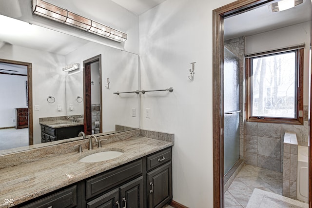 bathroom featuring a shower with door and vanity