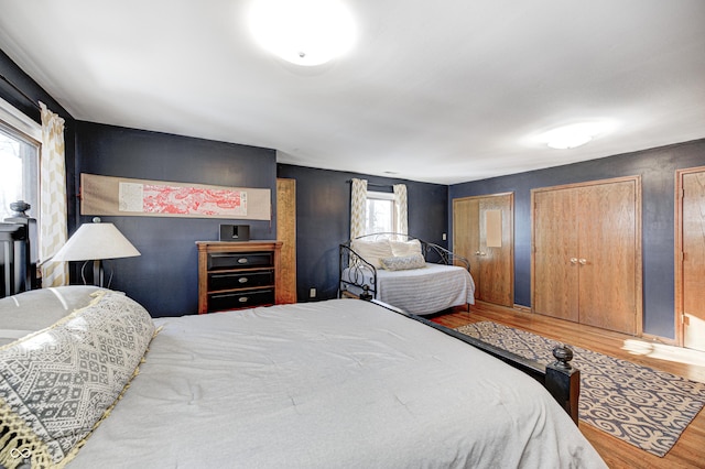 bedroom featuring multiple closets and hardwood / wood-style floors