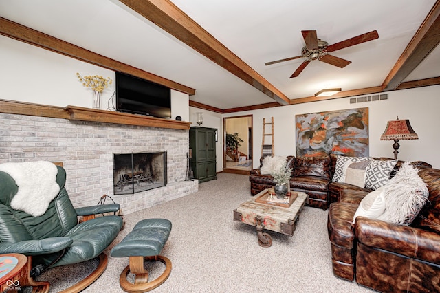 carpeted living room with ceiling fan, a fireplace, and beamed ceiling