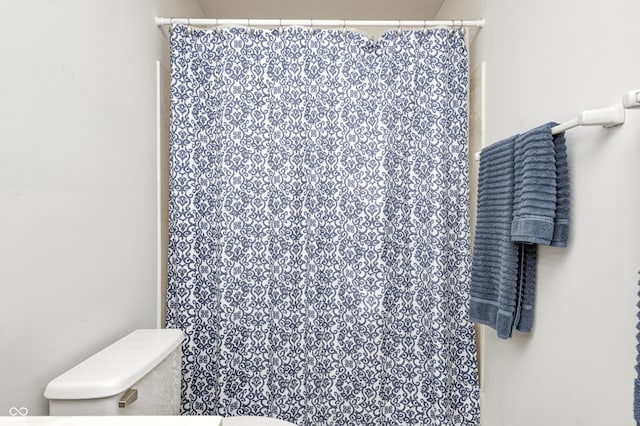 bathroom featuring toilet and a shower with shower curtain