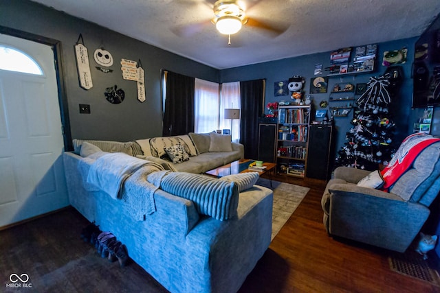 living room featuring a textured ceiling, dark hardwood / wood-style floors, and ceiling fan