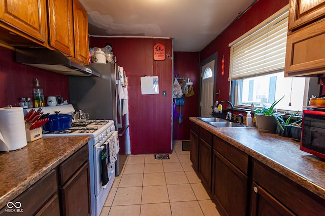 kitchen with white range with gas cooktop, sink, and light tile patterned floors