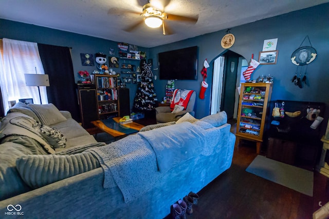 living room with a textured ceiling, dark hardwood / wood-style floors, and ceiling fan