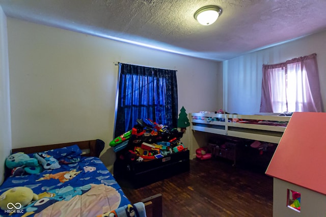 bedroom featuring a textured ceiling and dark wood-type flooring