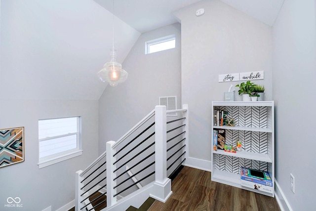 stairway with hardwood / wood-style floors and vaulted ceiling