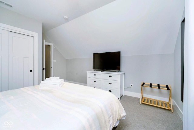 carpeted bedroom with a closet and lofted ceiling