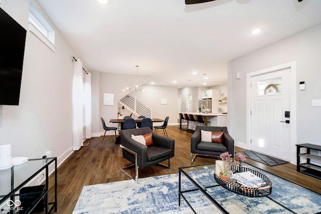 living room with dark hardwood / wood-style flooring and a chandelier