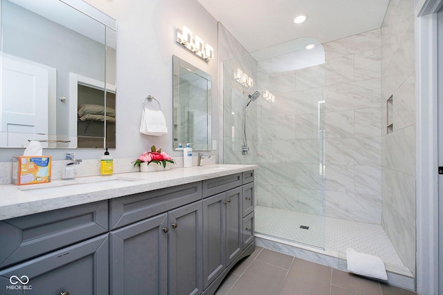 bathroom featuring tile patterned flooring, vanity, and tiled shower