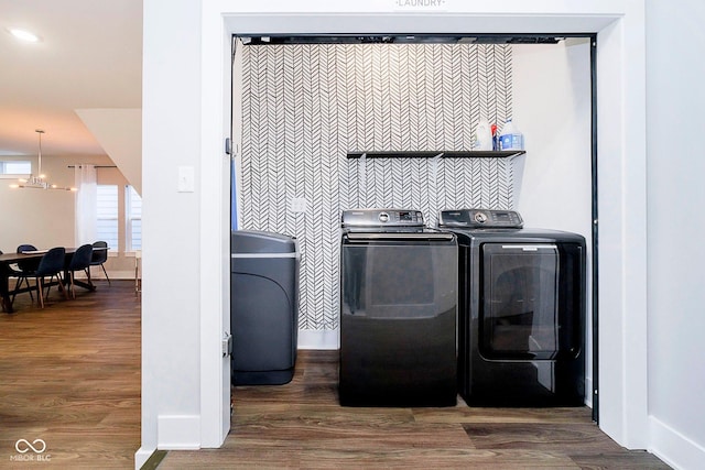 laundry room featuring an inviting chandelier, dark wood-type flooring, and independent washer and dryer