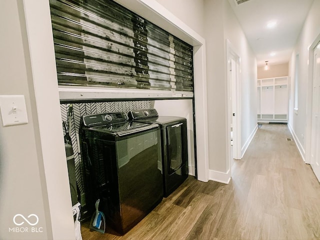 details featuring washing machine and dryer and hardwood / wood-style flooring