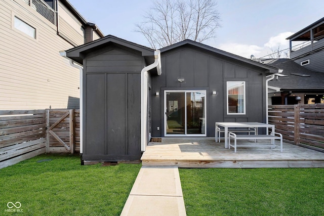 back of house with a lawn and a wooden deck