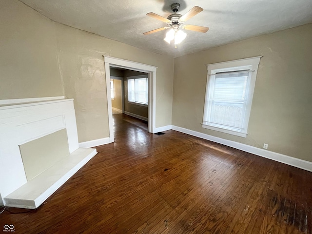 unfurnished living room featuring a textured ceiling, dark hardwood / wood-style flooring, and ceiling fan