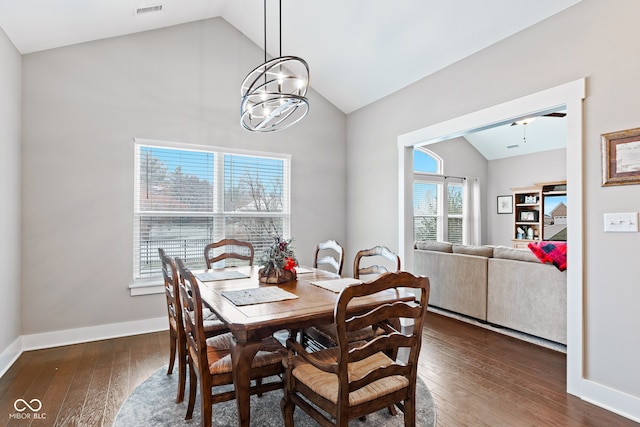 dining area featuring dark hardwood / wood-style flooring, ceiling fan with notable chandelier, and lofted ceiling